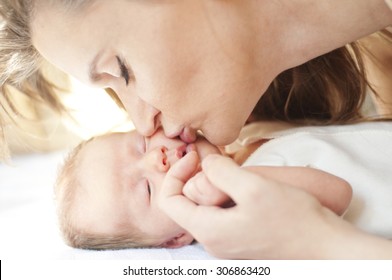 Mother Kissing Newborn Baby