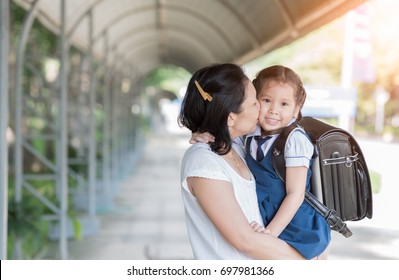 Mother Kissing Schoolgirl In Uniform Before Going To School, Love And Care Concept