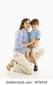 Mother Kneeling Down Holding Son Against White Background.