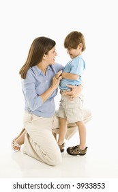 Mother Kneeling Down With Son Against White Background.