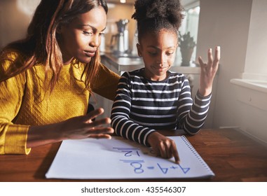 Mother learning child to calculate, black mother and daughter