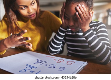 Mother learning child to calculate, child looking frustrated. Black woman and child - Powered by Shutterstock