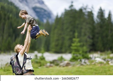 Mother Lifting Boy Up In Countryside