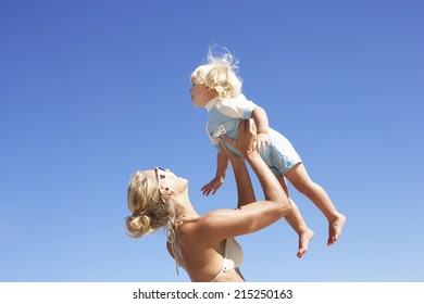 Mother Lifting Daughter Above Head, Smiling, Side View