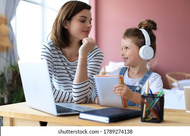 Mother and little daughter doing homework online. Distance learning online education. - Powered by Shutterstock