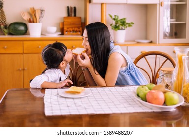 Mother and little daughter having fun with breakfast together at home kitchen in the morning,Healthy food concept,Carbohydrates
