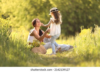 Mother And Little Daughter Having Fun In Summer Meadow With Yellow Flowers. Happy Family On Summer. Concept Of Healthy Family Without Allergies. High Quality Photo. 