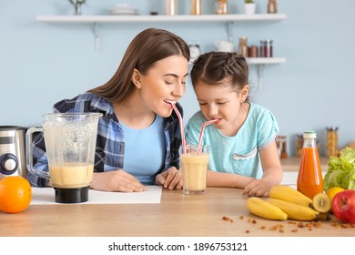 Mother and little daughter with healthy smoothie in kitchen - Powered by Shutterstock