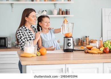 Mother and little daughter making healthy smoothie in kitchen - Powered by Shutterstock