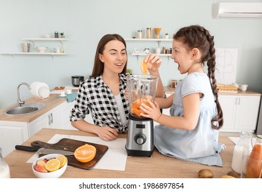 Mother and little daughter making healthy smoothie in kitchen - Powered by Shutterstock