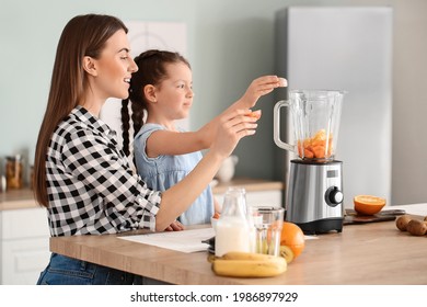 Mother and little daughter making healthy smoothie in kitchen - Shutterstock ID 1986897929