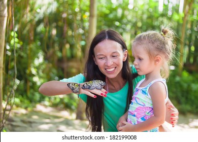 Mother with little daughter in the park butterflies
