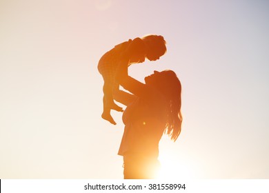 mother and little daughter play at sunset - Shutterstock ID 381558994