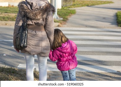 Mother with little daughter waiting to crosswalk street. Zebra crossing