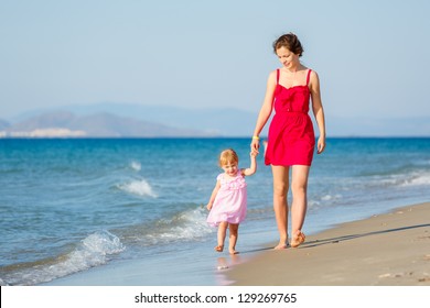 Mother And Little Daughter Walking On The Beach