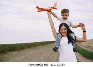 Mother with little son playing with toy plane