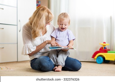 Mother looking at a book with her child son at home