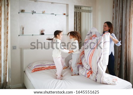 Similar – Relaxed mother and sons playing over the bed