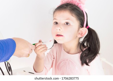 Mother Makes Make-up Her Daughter. Mother Putting Lipstick On Her Daughter. Mom Helping Little Daughter To Use Lipstick Before A Dance Performance.