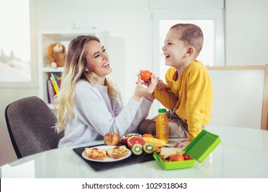 Mother Making Breakfast For Her Children In The Morning And A Snack For School