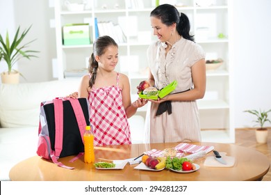 Mother Making Breakfast For Her Children In The Morning And A Snack For School