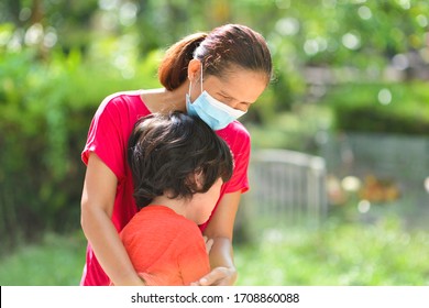 Mother With Mask Hugging Crying Child.Mom Hugs Son. People With Face Mask. Emotional And Sad Kid Preschooler.Corona Virus Pandemic Care.