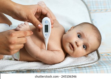 Mother Measures The Temperature Of A Sick Baby Frightened