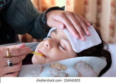 Mother Measuring Fever Of Her Sick Child.