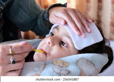 Mother Measuring Fever Of Her Sick Child.