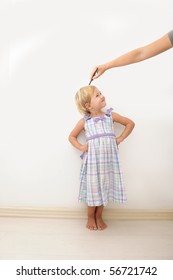 Mother Measuring Height Of A Cute Child