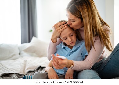 Mother measuring temperature of her ill kid. Sick child with high fever, mother holding thermometer. - Powered by Shutterstock