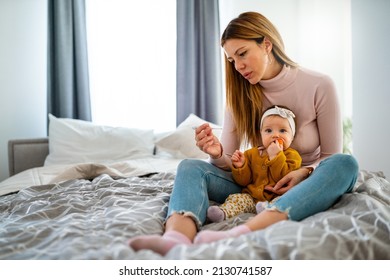 Mother Measuring Temperature Of Her Ill Kid. Sick Child With High Fever, Mother Holding Thermometer.