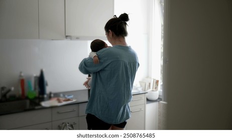 Mother multi-tasking in the kitchen, holding her baby while preparing a meal, natural light streaming through the window, highlighting the challenges and beauty of modern parenting in a home setting - Powered by Shutterstock