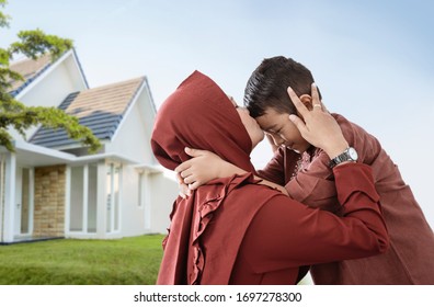 mother muslim kiss her son in front of their house