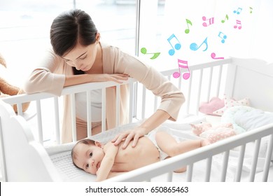 Mother Near Baby Lying In Cradle. Lullaby Songs And Music Concept