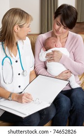 Mother With Newborn Baby Talking With Health Visitor At Home