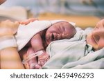 Mother and newborn. Child birth in maternity hospital. Young mom hugging her newborn baby after delivery. Woman giving birth. First moments of baby life after labor.