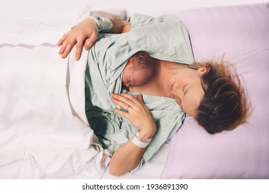 Mother And Newborn. Child Birth In Maternity Hospital. Young Mom Hugging Her Newborn Baby After Delivery. Woman Giving Birth. First Moments Of Baby Life After Labor.