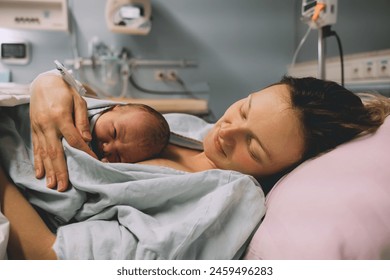 Mother and newborn. Child birth in maternity hospital. Young mom hugging her newborn baby after delivery. Woman giving birth. First moments of baby life after labor. - Powered by Shutterstock