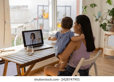 mother on her back with her daughter in her arms sitting on a video call with the doctor - virtual appointment, medicine at home - Powered by Shutterstock