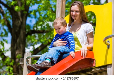 Mother On Son Playing On A Jungle Gym