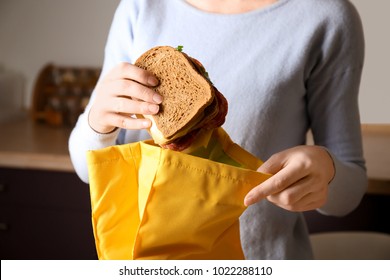 Mother Packing Food Into School Lunch Bag Indoors