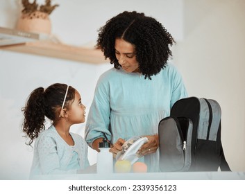 Mother packing lunch for her girl child for health, wellness snacks in the kitchen of their home. Happy, bonding and young mom talking and preparing food for her kid for school in their family house. - Powered by Shutterstock