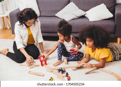 Mother Parent Playing With Children Learning To Solve Puzzle Toy At Home Apartment. Nanny Looking Or Childcare At Living Room Black People.