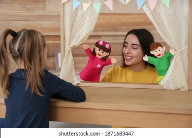 Mother performing puppet show for her daughter at home