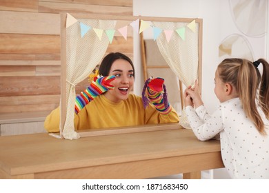 Mother Performing Puppet Show For Her Daughter At Home