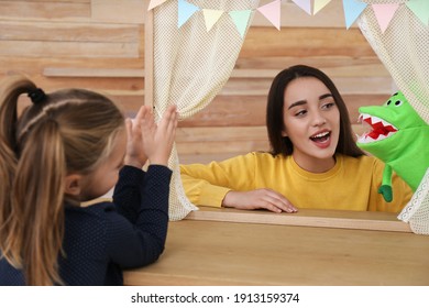 Mother Performing Puppet Show For Her Daughter At Home