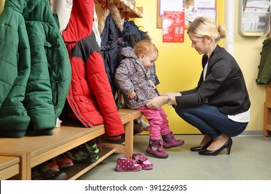 Mother picking up her child from a Kindergarten in wardrobe 2