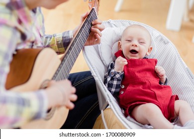 Mother Play Guitar To Her Son. Mom And Baby Singing And Playing Guitar.   