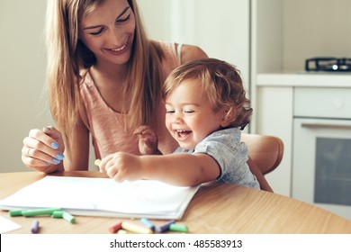 Mother playing with her 1,4 years old son, drawing together